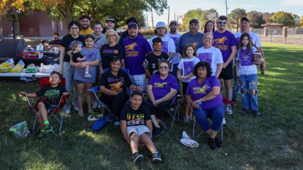 Family of football player at homecoming under tree